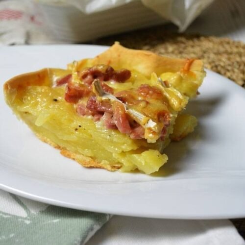 Lamelles de pomes de terre posée sur une pâte recouvertes de lardons et de camembert